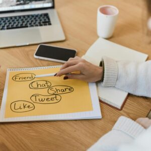 Two women planning social media marketing strategy with a laptop and smartphone.
